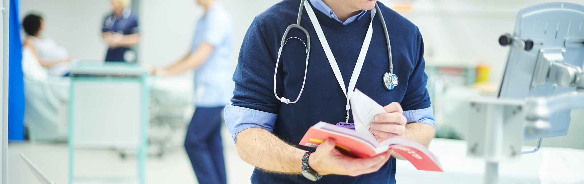 Doctor in clinical setting with a book