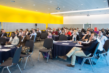 A group of people sitting in a room</p>
<p>Description automatically generated