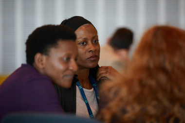 A group of people sitting in a room</p>
<p>Description automatically generated