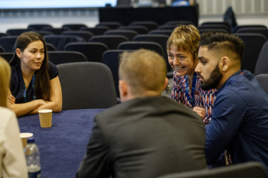 A group of people sitting at a table</p>
<p>Description automatically generated